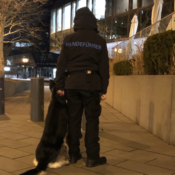 Diensthundeführer mit Hund bei Nacht Diensthundeführer mit Hund